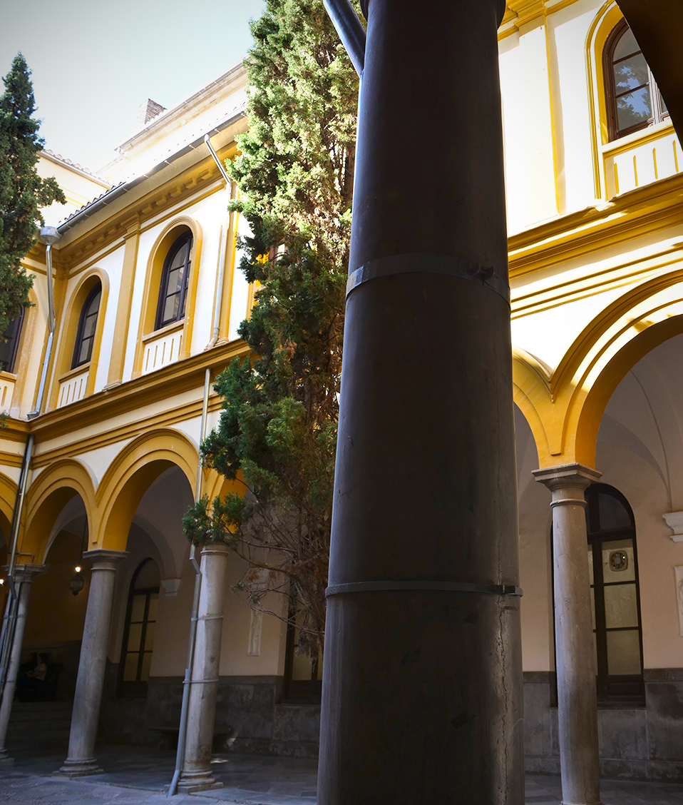 Los rayos de sol alcanzan la planta superior de la Facultad de Derecho, mientras que su patio, columnas y pasillos permanecen a la sombra