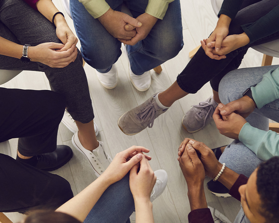 Imagen desde arriba de un grupo de personas sentadas en círculo mientras hablan