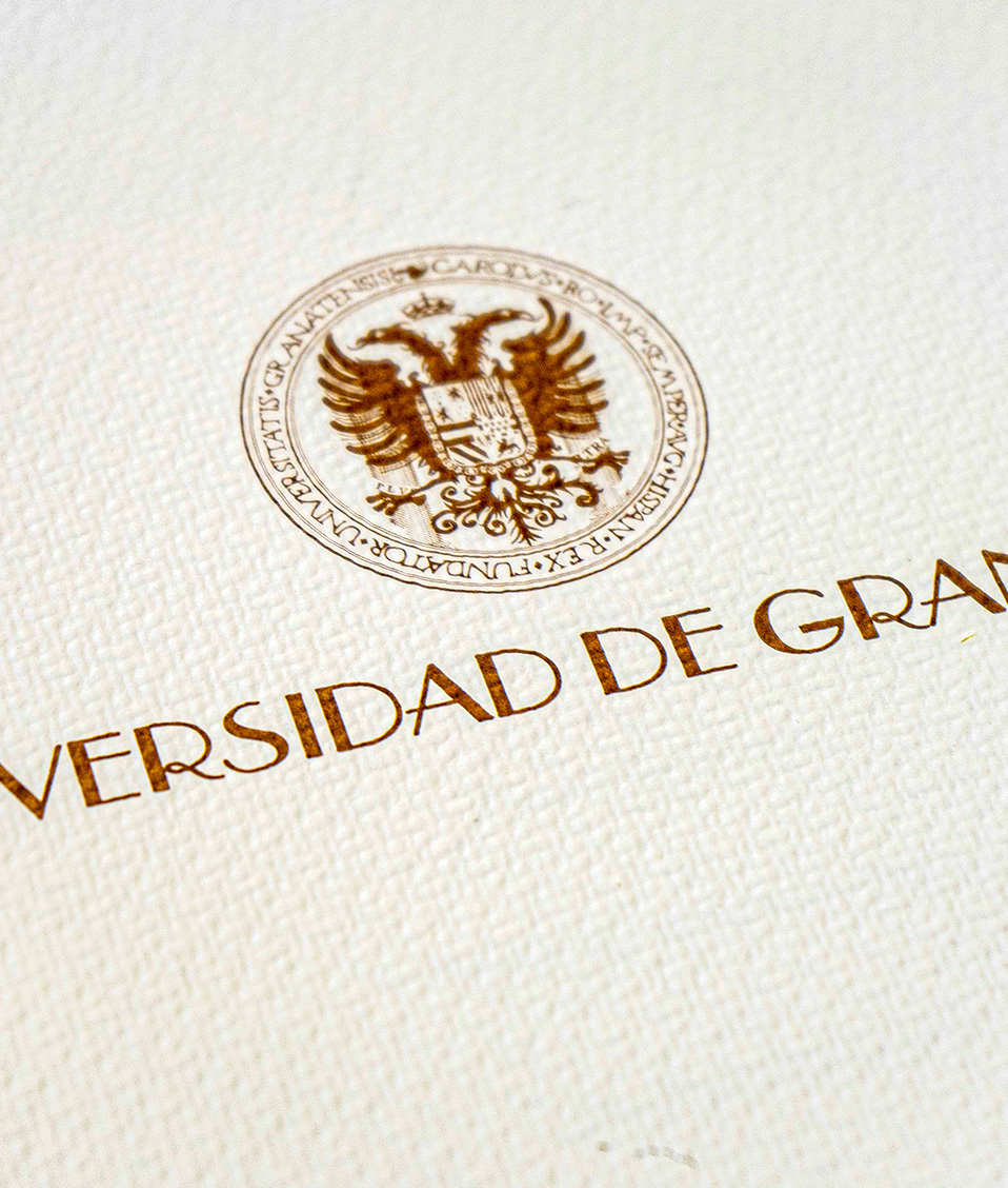 Logotipo antiguo de la Universidad de Granada sobre papel con textura
